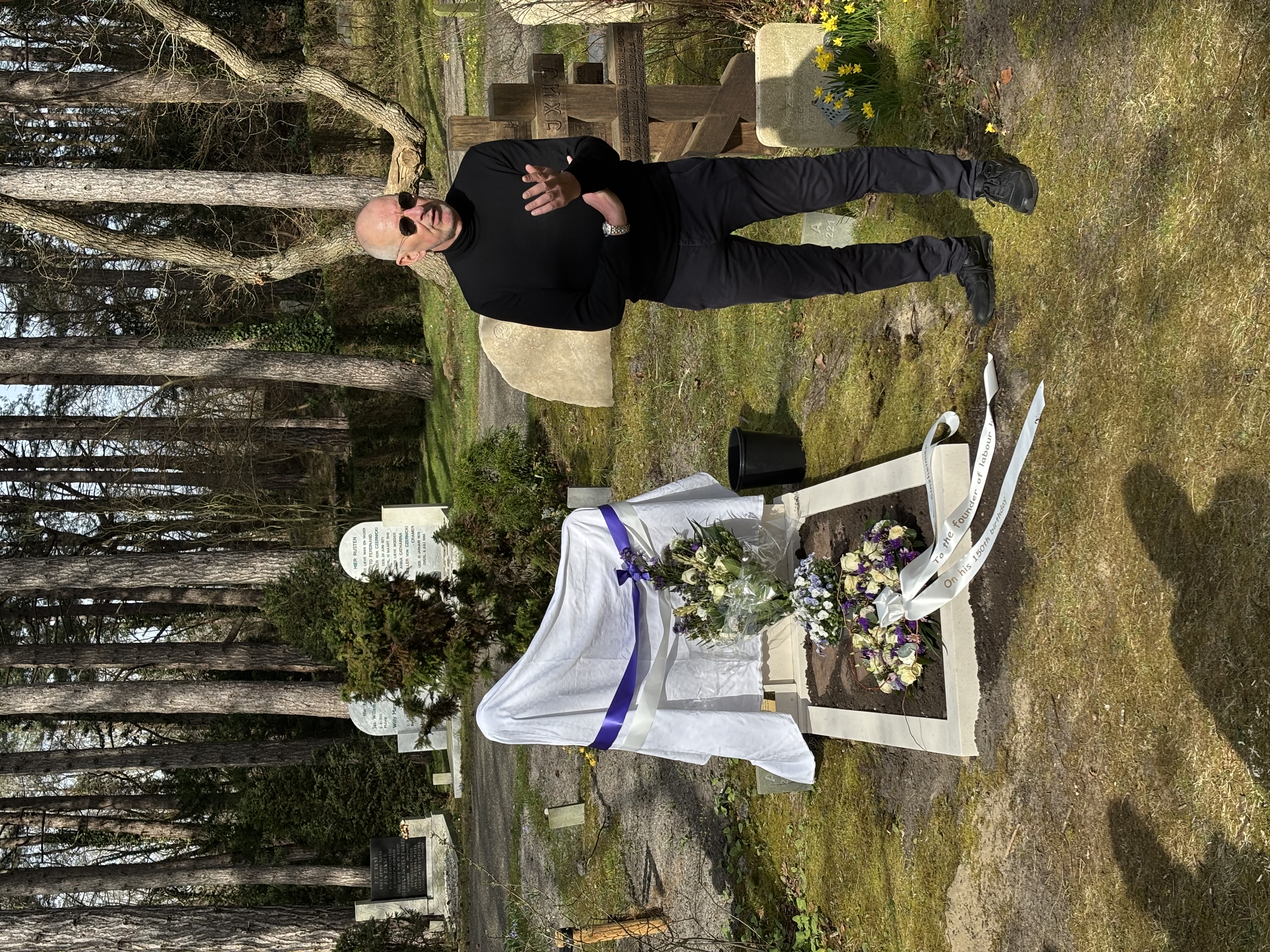 flower arrangement,flower bouquet,shoe,adult,male,man,person,glasses,wristwatch,tomb