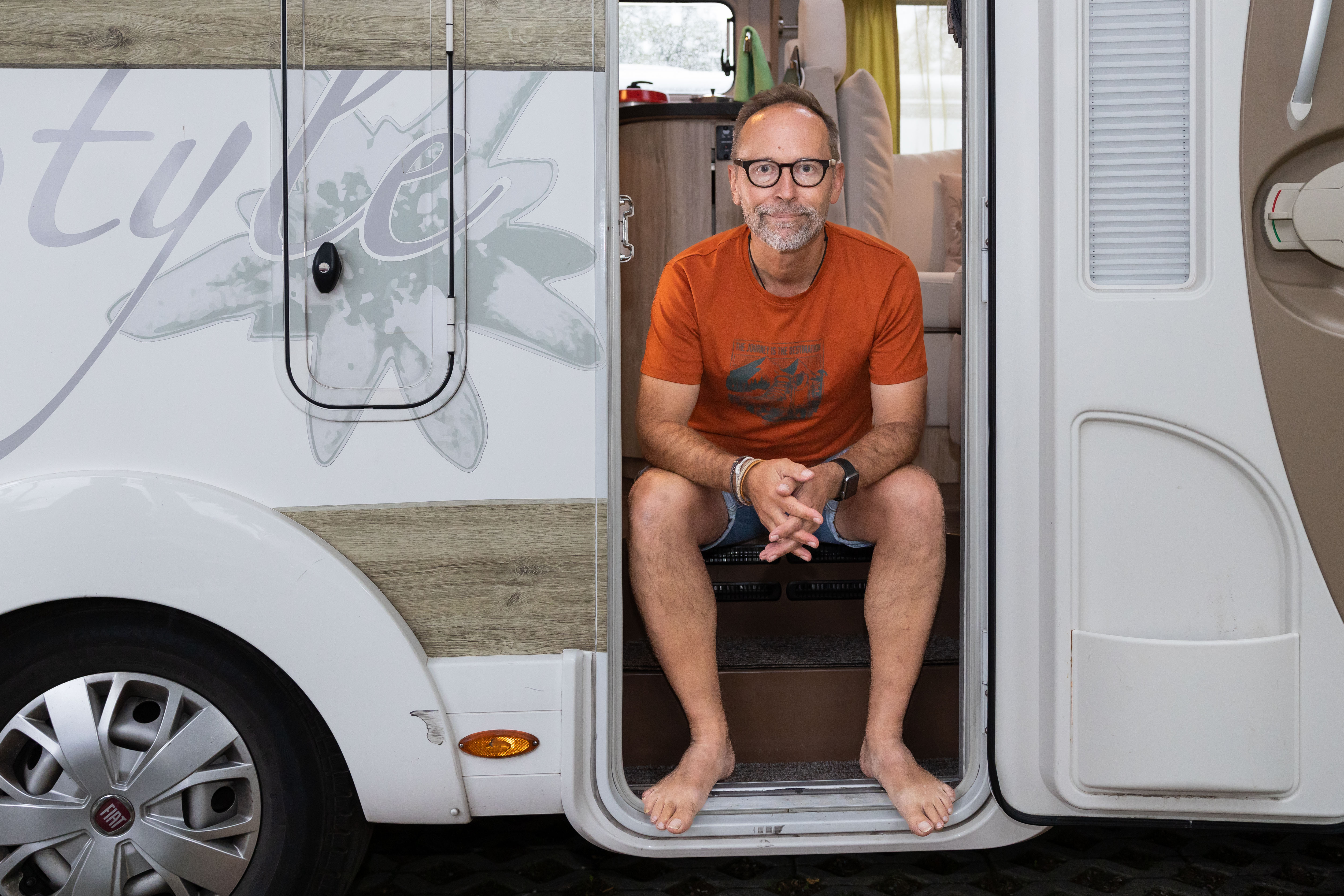 wheel,alloy wheel,spoke,sitting,person,glasses,wristwatch,man,adult,male