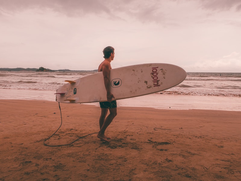 sand,beach,water,surfboard,person,huamn,ocean,waves