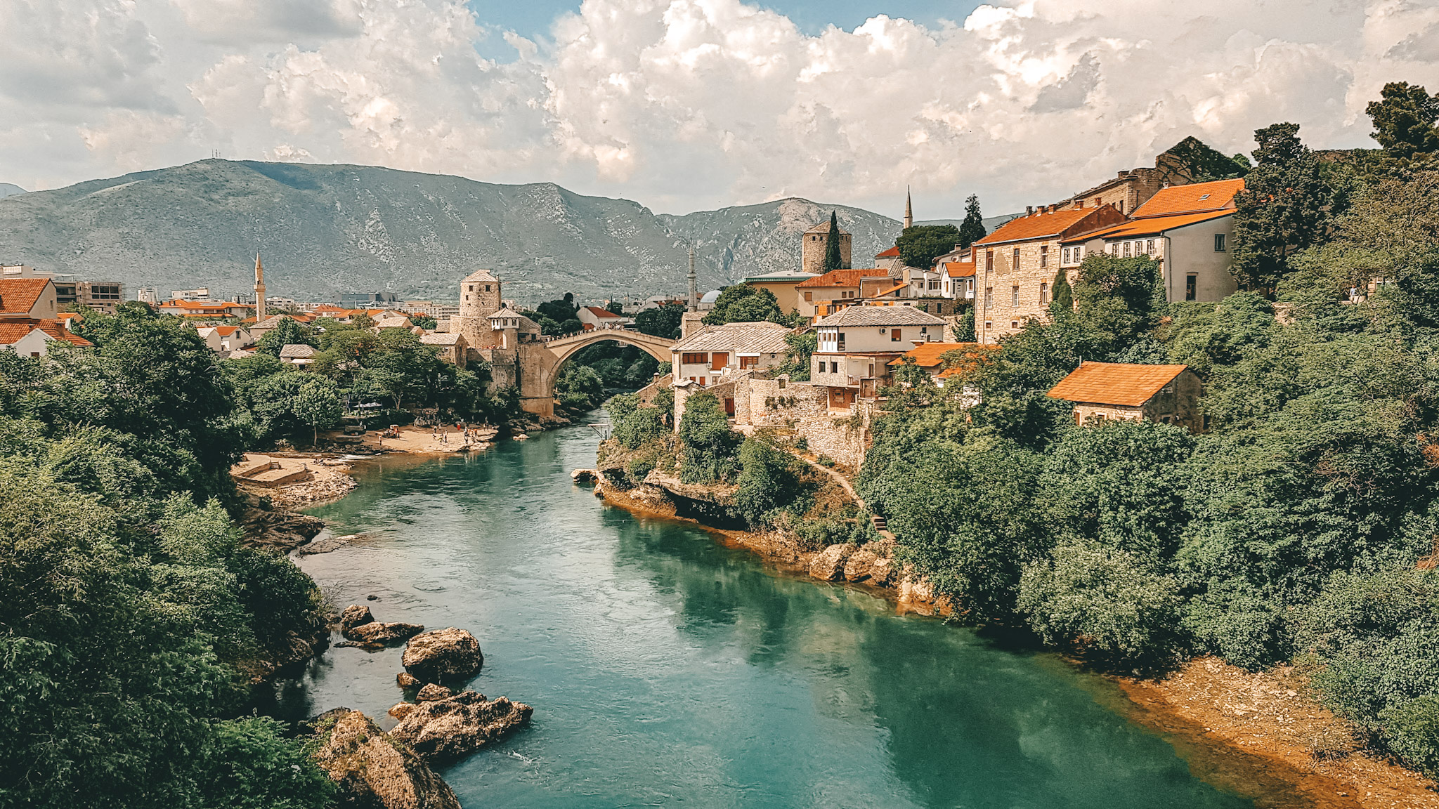 water,mostar,bridge,buildings,sky,clouds