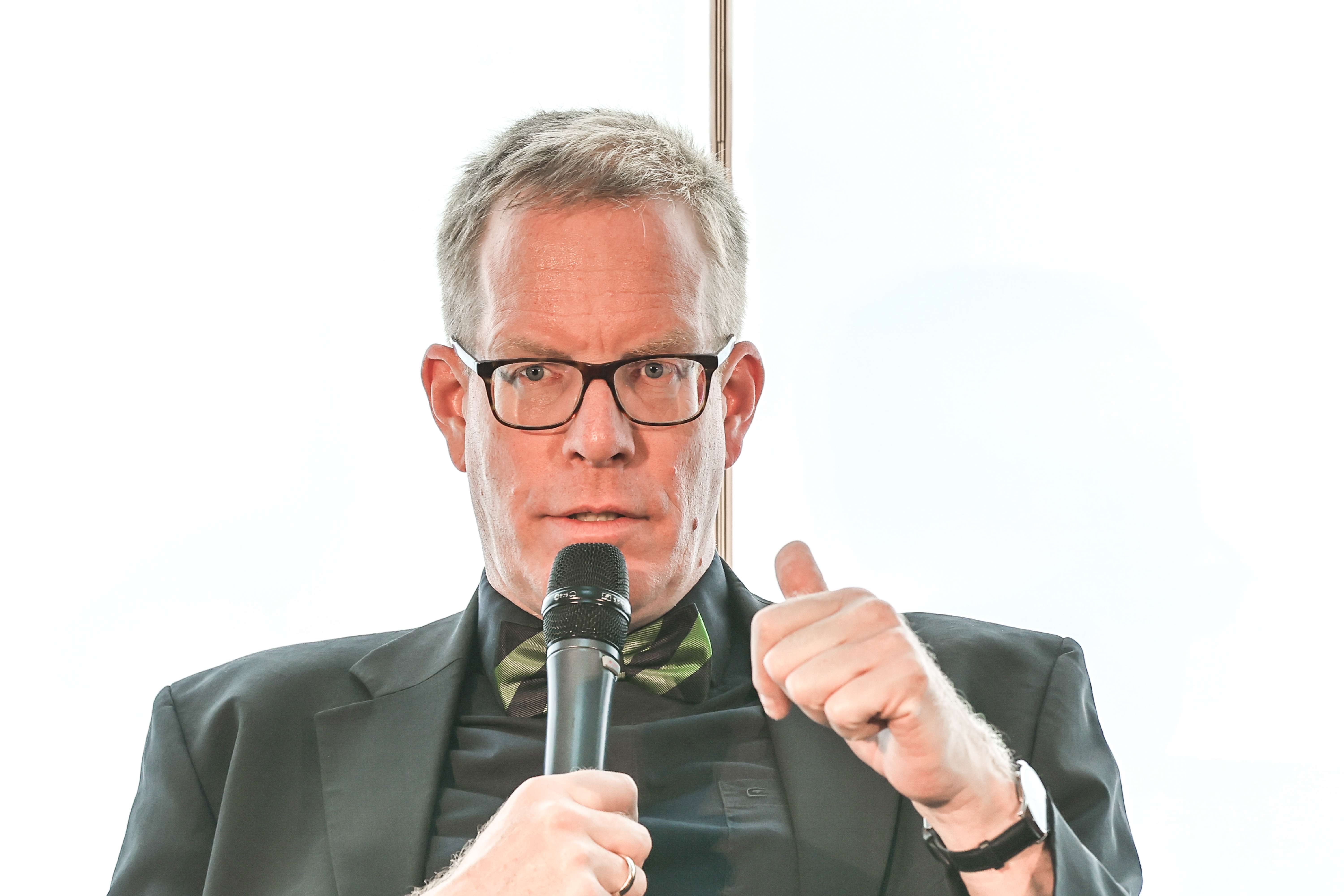 microphone,finger,person,people,formal wear,tie,adult,male,man,crowd